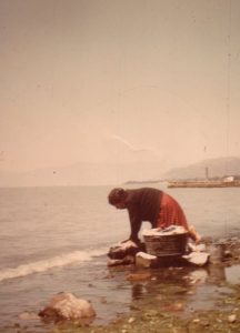 The lake was not only valuable as a recreational resource, it was also a workplace. The village women, lacking washing machines in their homes, used the lake instead, pounding their clothes on stones at the lake’s edge. The old pier is in the background. Tamara and her sister Jill often used to help wash the family’s clothes "on the big washing rocks" before spreading them out on the rocks to dry. "It was an all-day affair, and lots of gossip went down while the wash was being done". ﻿Photo by Beverly Johnson. All rights reserved.