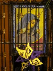 A portrait of Mary can be seen the the window of a Mexican chapel, behind the wrought iron grillwork © Edythe Anstey Hanen, 2014