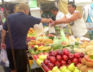 Red and green apples, peaches, pears, bananas, mangos and mamey -- a shopper selects ripe fruit at a traveling Mexican market known as a tianguis. © Daniel Wheeler, 2009