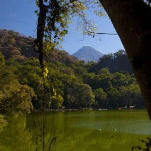 A rumbling giant peeks over the crater rim into peaceful Laguna La Maria, Mexico © John Pint, 2012