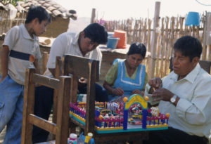 Maximino Santiago Garcia and his family work on colorful tableaus that depict life in rural Mexico. © Arden Aibel Rothstein and Anya Leah Rothstein, 2007