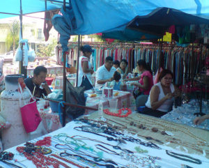 Jewelry takes center stage in this section of a Mexican tianguis. To the right, an open air restaurant serves simple meals, and a clothing stall can be seen at the rear. © Daniel Wheeler, 2009