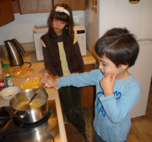 Ana Cristina Wright Ramirez supervises while her brother Santiago James prepares a quintessential Mexican food -- corn. © Anthony Wright, 2009