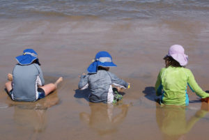 Children wear droopy hats to protect them rom the sun as they enjoy a day at the beach on Mexico's Nayarit Riviera © Christina Stobbs, 2011