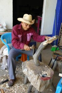 A Mexican artisan at the initial stage of crafting an alebrije. The wood's natural shape guides his imagination. © Alan Goodin 2007