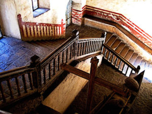 Looking down through the dim light from the upper landing of the grand staircase, one can imagine the people who passed this way before. The Ex-Convento de San Pablo Apostol in Yuriria, Michoacan dates from the 16th century. This original photograph forms part of the Olden Mexico collection. © Darian Day and Michael Fitzpatrick, 2010