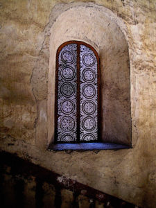 Window coverings allow faint light into the staircase through an elaborate and beautiful pattern of worked metal. The Ex-Convento de San Pablo Apostol in Yuriria, Michoacan dates from the 16th century. This original photograph forms part of the Olden Mexico collection. © Darian Day and Michael Fitzpatrick, 2010