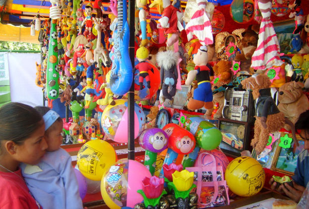 Located about 50 kilometers southwest of the state capital of Aguascalientes, the town of Calvillo hosts an annual guava fair. Stalls selling food and merchandise appear in the plaza. This one, filled with toys, entices a little girl and her baby sister. © Diodora Bucur, 2009