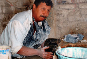 In this area of Jalisco, the typical country-workshop approach to shaping obsidian is dangerous. Here, a piece of the black glass is being pushed into a table saw. © John Pint, 2009