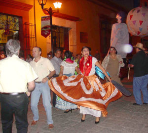 A young girl dancing in traditional regional dress.