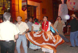 A young girl dancing in traditional regional dress.