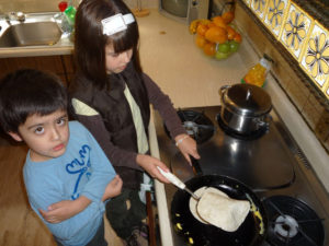 Ana Cristina Wright Ramirez flips flour tortillas for a Mexican brunch. Her little brother, Santiago James, looks on. © Anthony Wright, 2009