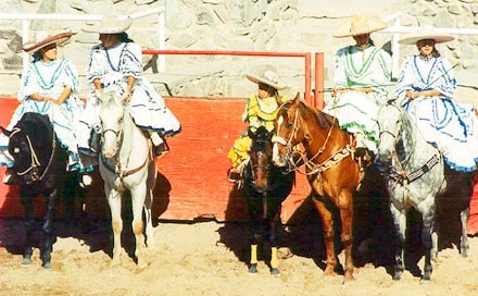 The Adelitas, young women of a mounted drill team rest before they ride in the Escaramuza. Photography by Gilbert W. Kelner. © 2000