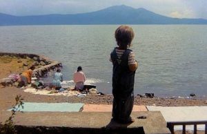 ﻿Standing on the garden wall, Micah watches as women wash clothes in Lake Chapala in 1972. When Marsha first moved to Ajijic, the village had no washing machines and the electricity supply was sporadic at best. Photo in family collection of Marsha Sorensen; all rights reserved.