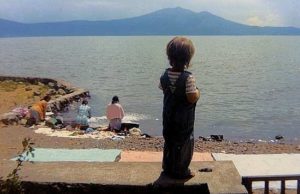 Standing on the garden wall, Micah watches as women wash clothes in Lake Chapala in 1972. When Marsha first moved to Ajijic, the village had no washing machines and the electricity supply was sporadic at best. Photo in family collection of Marsha Sorensen; all rights reserved.