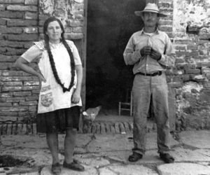 ﻿Ajijic in 1972 was a much more rural place, where the pace of life was slower and more in tune with the seasons. A couple who were near-neighbors of Marsha pose for a photo outside their home. Marsha recalls that "I remember women with hair this long sitting in front of their houses on the days they washed their hair in order to let it dry. Unbraided, their har would hang to the ground." Photo in family collection of Marsha Sorensen; all rights reserved.