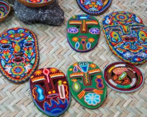 Finely wrought Huichol masks. The bright yarnwork and intricate beaded motifs are applied to a pinewood base, which has been coated with beeswax. © Kinich Ramirez, 2006