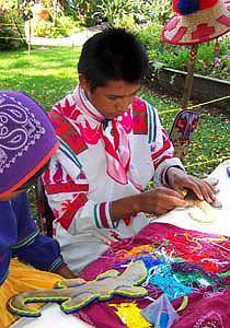 Each piece of beaded art is made by individually placing the beads into wax and pine resin spread on a wooden base.