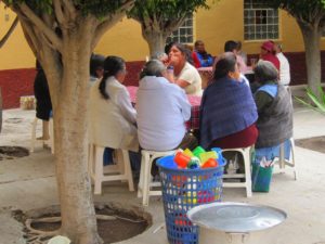 In the Parroquia's sunny courtyard, long tables covered with red and white checked tablecloths are set up the weekly luncheon. © Edythe Anstey Hanen, 2013