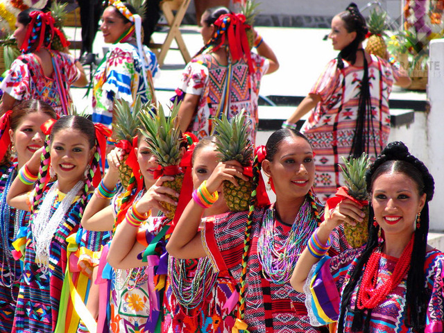 Women from Papaloapam in their colorful dress hold pineapples as props for a traditional dance during Oaxaca's Guelaguetza celebration. © Oscar Encines, 2008