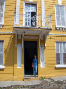 Rosalind Chenery fell in love with a beautiful three storey, art nouveau town house in Chapala, Mexico. She stands in the dooorway beside the crumbling sidewalk in front of her new home. © Arden Murphy, 2009