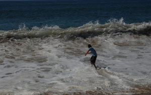 Melaque skim boarder rides a foam slick towards a boil of sea, sand and air. Young men participate annually in competitions to determine the Mexican representative at the World Skim Boarding Championships. © Gerry Soroka, 2009