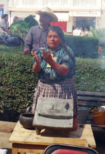 Esther Ramon of San Lorenzo shapes stone-ground corn. She and her daughter never slowed down while feeding a steady supply of hungry customers.