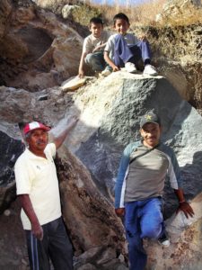 Members of the Cocula family pose with a huge basalt rock from which they plan to carve a mortar two meters in diameter. © John Pint, 2012
