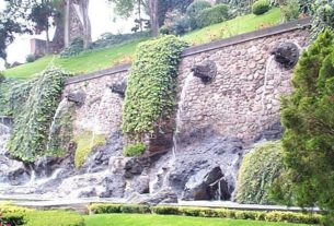 Waterworks in the gardens provide background for family photos. Here the water flows out of Aztec looking figures protruding from the wall.