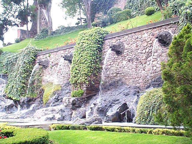 Waterworks in the gardens provide background for family photos. Here the water flows out of Aztec looking figures protruding from the wall.