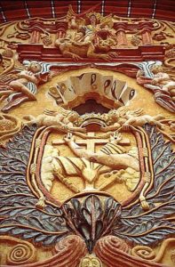 The Archangel Michael stands above the Ojo de Dios, the eye of God, an assemblage of angels revealing the symbol of the Franciscan Brotherhood on the facade at Concá.