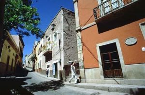 A man carrying freshly baked bread walks past the rust-colored entrance to the museum and former home of Diego Rivera, one of Mexico's greatest artists.
