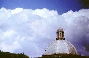 The dome of one of San Miquel's churches seems insignificant against the billowing clouds, perhaps filled with the very angels whoose wooden images clutter the antique shops of the city.