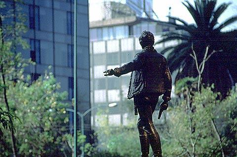 As if gesturing to pedestrians to not cross the Paseo de la Reforma until the traffic clears, a monument to one of Mexico's heroes gazes into the Zona Rosa. Photography by Bill Begalke © 2001