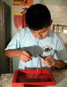 A boy intently works with jewelry pliers in one of the vocational classes at Mexico's Villa de los Niños. © John Pint, 2012