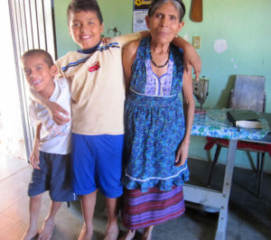 A weaver from the Tixinda women's cooperative in Pinotepa de Don Luis, Oaxaca, plays with her grandsons. 'Tixinda' means 'sacred caracol' in the Mixtec language. © Geri Anderson, 2011