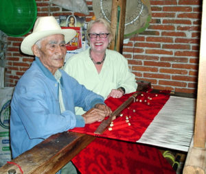 Jose Chavez Ruiz, age 85, is nearly finished with his last rug and explains to Norma Hawthorne that he still weaves about three to four hours a day. This photo was taken in August 2006. Jose died two months later. His son, Federico, and grandchildren, Eric, Janet and Omar continue the family weaving traditions.© Norma Hawthorne 2008