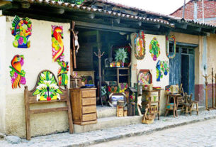A menagerie of colorful and rustic-finish furniture spills out of a doorway, hinting at the variety inside.