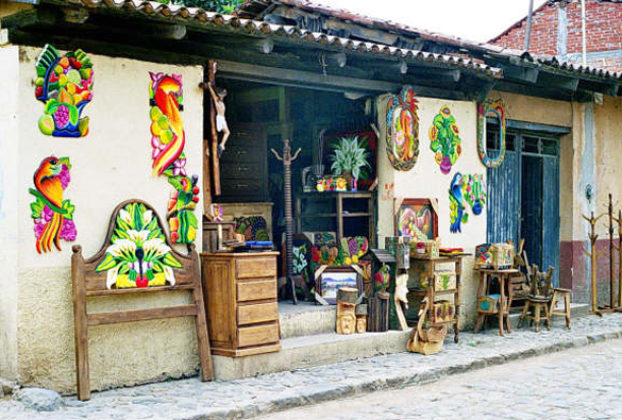A menagerie of colorful and rustic-finish furniture spills out of a doorway, hinting at the variety inside.