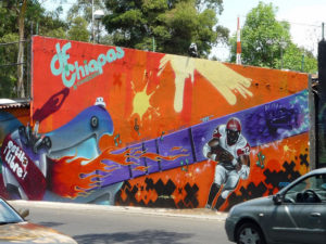 This graffiti mural on the outer wall of Mexico City's Estadio Azteca (Aztec Stadium) depicts an "American football" player. It reads "Free Style: the DF Chiapas connection." © Anthony Wright, 2009