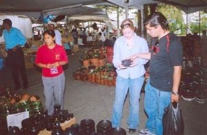 Katie Cowger (C) of Ashland, Oregon, and Carlos Torres, (R) of Guanajuato purchase pottery from Tzintzuntzun