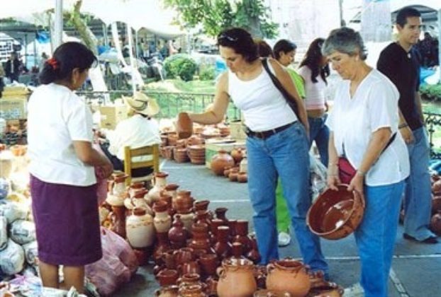 Artisan Elodia Bernave (L) speaks with Laura de la Vega and her mother Laura Rodríguez of Morelia, at the crafts fair