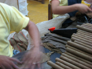 Cigars are rolled and finished by hand at Mexico's famous Te-Amo cigar factory. He worked with a strange, fat moon-shaped blade — known as a chaveta — as he crafted the final touches to each cigar. Oblivious of my clicking away, he cut and fit. My high-speed camera failed to catch his hands, except as a blur. © William B. Kaliher, 2010