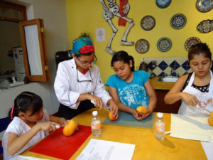 Students working with dull knives learn to peel mangoes for a fruit smoothie. Chef Pilar Cabrera's Casa de los Sabores Cooking School offers a class for children. © Alvin Starkman, 2011