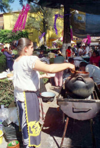 A girl helps out by tending a pot of pozole during the Purepecha food show in Uruapan. Such round clay pot are also popular for cooking beans.
