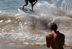 Silled as many champions, a A young Mexican skimboarder catches a wave on the shore of Melaque, Jalisco. © Gerry Soroka, 2010