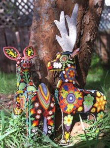 Huichol icons cover the bodies of deer carved from pinewood. The motifs are created wih tiny beads applied one by one to an adhesive layer of beeswax.