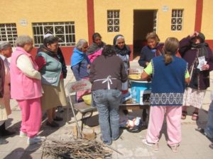 Demonstraton of a virtually smokeless stove, no more than a foot wide, that is fed branches of wood — mesquite or any brush found on the roadside. © Edythe Anstey Hanen, 2013