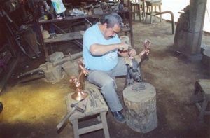 Abdon Punzo Angel works on copper dragons in his shop in Santa Clara del Cobre.