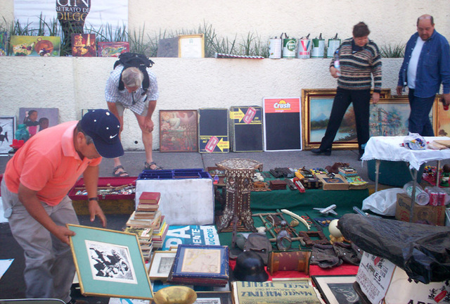 A lone foreign tourist (back left) carefully carries out an inspection of the wares.